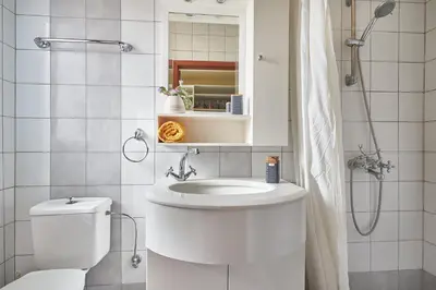 a white bathroom with a toilet and a sink at Villa Eremia in Pastida