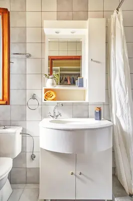 a white bathroom with a sink and a toilet at Villa Eremia in Pastida