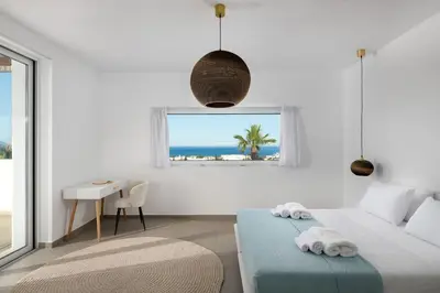 a bedroom with a bed and a table and a window at Sunset Hill Villa Rhodes in Gennadi