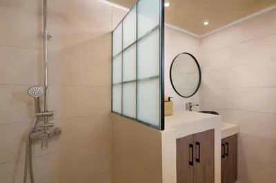 a bathroom with a shower and a sink and a mirror at Antheia Traditional House in Archangelos