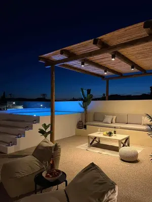 a patio with a couch and a table at night at Antheia Traditional House in Archangelos