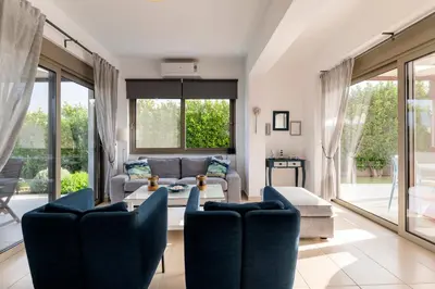 a living room with a couch and a table and chairs at Filoxenia Villas in Gennadi