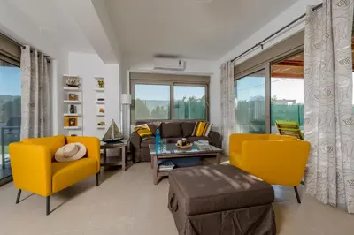 a living room with yellow chairs and a couch at Filoxenia Villas in Gennadi