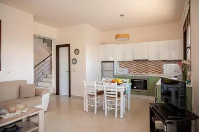 a kitchen and living room with a table and chairs at Petra Villas in Gennadi