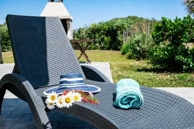 a hat and a towel and flowers on a chair at Petra Villas in Gennadi