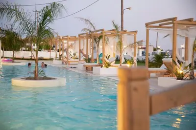 a swimming pool with trees and people in the water at Alia Suites and Spa in Haraki