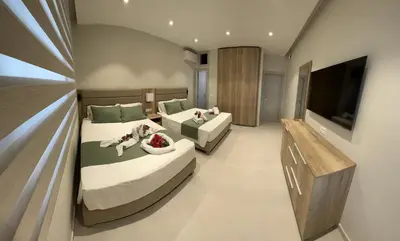 a bedroom with two beds and a flat screen tv at Samanthas LUXURY APARTMENT in Haraki