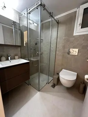 a bathroom with a shower and a toilet and a sink at Samanthas LUXURY APARTMENT in Haraki