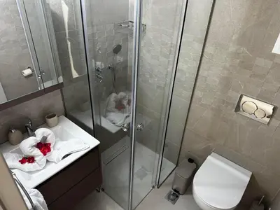 a bathroom with a shower and a toilet and a sink at Samanthas LUXURY APARTMENT in Haraki