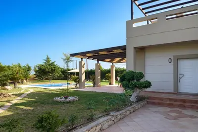 a house with a patio and a swimming pool at Evergreen Seaside Villa with private pool in Faliraki