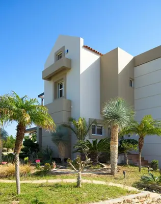 a building with palm trees in front of it at Evergreen Seaside Villa with private pool in Faliraki