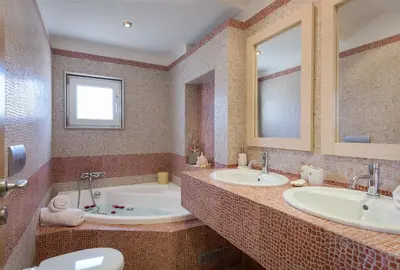 a bathroom with two sinks and a tub at Evergreen Seaside Villa with private pool in Faliraki