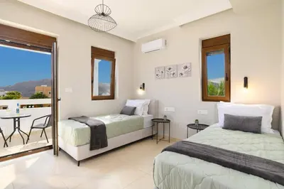 a bedroom with two beds and a balcony at Villa Pandora Lindos by Villa Plus in Líndos