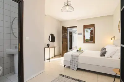 a bedroom with a bed and a bathroom at Villa Pandora Lindos by Villa Plus in Líndos