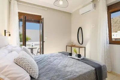 a bedroom with a bed with a view of the ocean at Villa Pandora Lindos by Villa Plus in Líndos