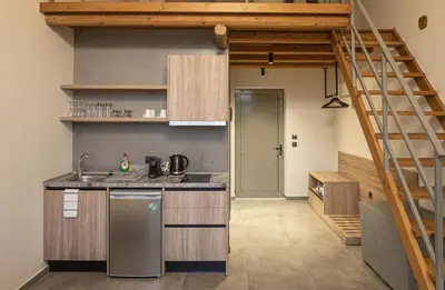 a kitchen with a stairs leading to a loft at Haraki Luxury Villas in Haraki