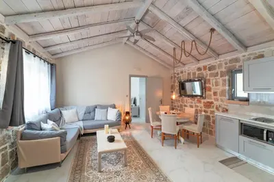 a living room with a couch and a table at AGROTOPIA Guesthouses in Theologos