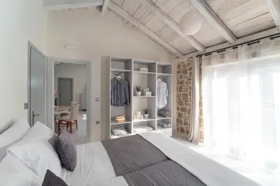 a bedroom with a bed and a room with a desk at AGROTOPIA Guesthouses in Theologos