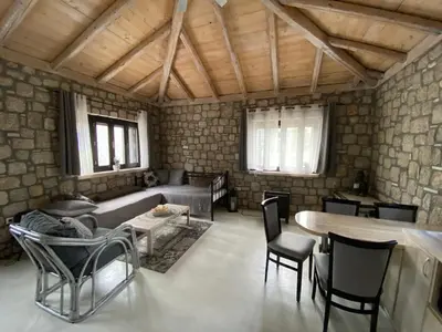 a living room with a couch and a table and chairs at AGROTOPIA Guesthouses in Theologos