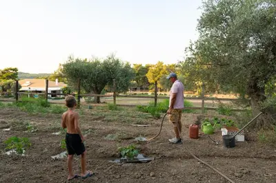 a man and a boy standing in a garden at AGROTOPIA Guesthouses in Theologos