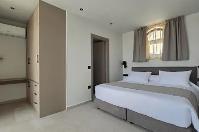 a bedroom with a large bed and a window at Trapezia Luxury Living in Kolimbia
