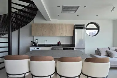 a kitchen with a table and some white chairs at Trapezia Luxury Living in Kolimbia