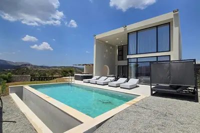 a house with a swimming pool and a tv at Trapezia Luxury Living in Kolimbia