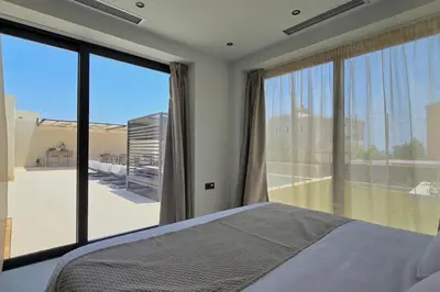 a bedroom with a bed and a large window at Trapezia Luxury Living in Kolimbia