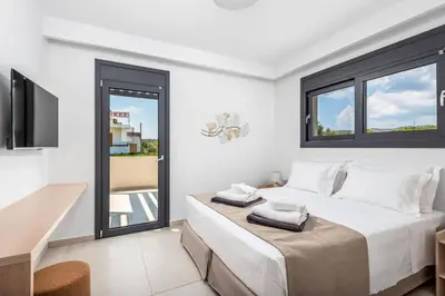 a bedroom with a large bed and a balcony at Villa Apollon Lindian Palm by Villa Plus in Kiotari