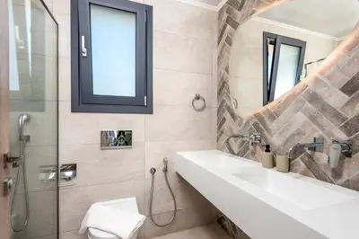 a bathroom with a sink and a glass shower at Villa Apollon Lindian Palm by Villa Plus in Kiotari