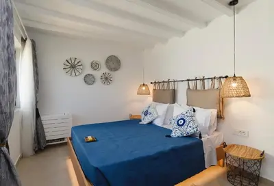 a bedroom with a bed with blue sheets and pillows at 5 SENSES in Pefki Rhodes