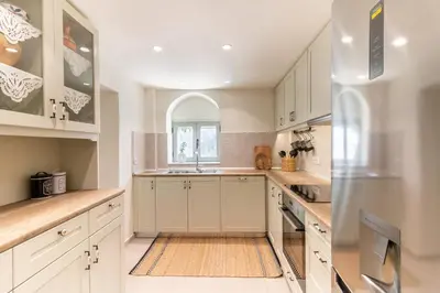 a kitchen with white cabinets and a sink at Mounouria House Koskinou in Koskinou