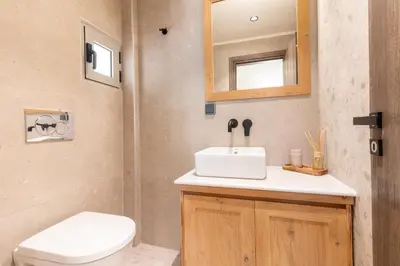 a bathroom with a sink and a toilet and a mirror at Mounouria House Koskinou in Koskinou