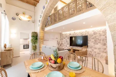 a kitchen and living room with a table and chairs at Mounouria House Koskinou in Koskinou