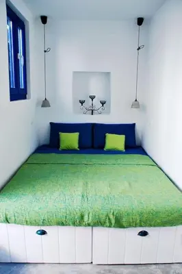 a bedroom with a large bed with green sheets at seasalthouse - famous tv location in Koskinou