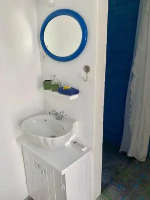 a bathroom with a sink and a mirror on the wall at seasalthouse - famous tv location in Koskinou