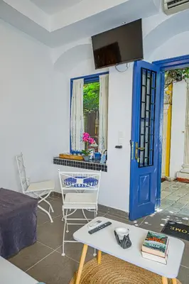 a living room with a blue door and chairs at Kali Strata 1 - Downtown in Symi