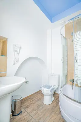 a white bathroom with a toilet and a sink at Kali Strata 1 - Downtown in Symi