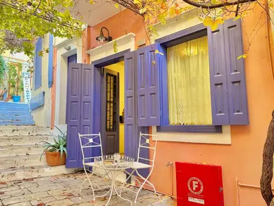 a colorful house with purple doors and a table outside at Kali Strata 1 - Downtown in Symi