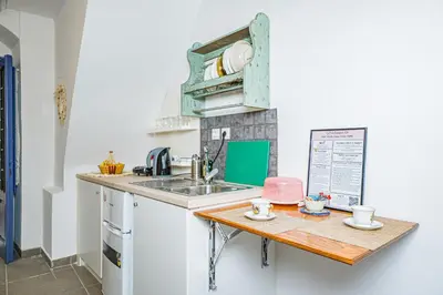 a small kitchen with a sink and a wooden table at Kali Strata 1 - Downtown in Symi