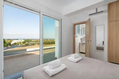 a bedroom with a bed and a large window at Villa Katerina - Soroni in Rhodes Town
