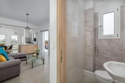 a bathroom with a shower and a living room at Villa Katerina - Soroni in Rhodes Town