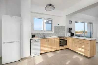 a kitchen with wooden cabinets and a white refrigerator at Villa Katerina - Soroni in Rhodes Town