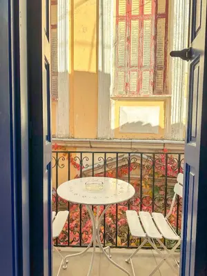 a table and chairs on a balcony with a window at Kali Strata 2 - Downtown in Symi
