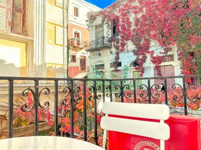 a white bench sitting in front of a building at Kali Strata 2 - Downtown in Symi