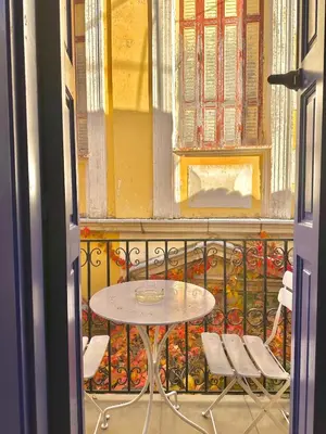 a table and chairs in a balcony with a window at Kali Strata 2 - Downtown in Symi