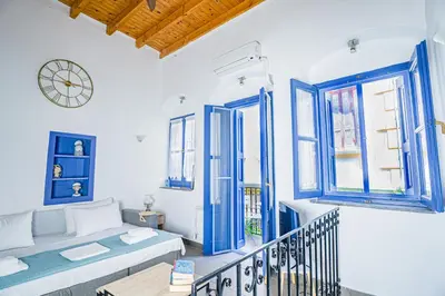 a living room with a couch and a clock on the wall at Kali Strata 2 - Downtown in Symi