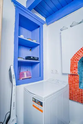 a white washing machine in a room with a blue cabinet at Kali Strata 2 - Downtown in Symi