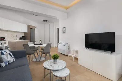 a living room with a couch and a flat screen tv at Aegean Retreat Luxury Apartment in Rhodes Town