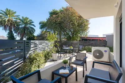 a patio with chairs and tables and a fan at Aegean Retreat Luxury Apartment in Rhodes Town